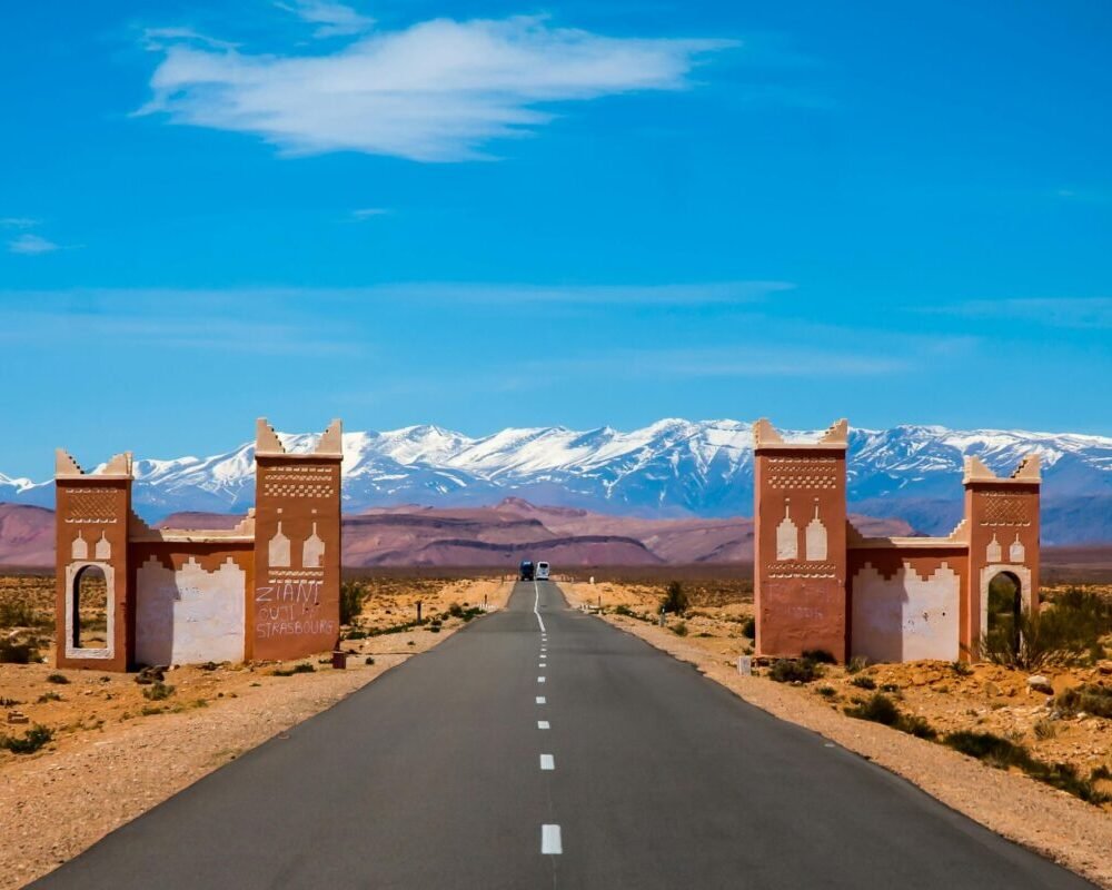 Explore the open road leading to Morocco's Atlas Mountains on a sunny day.