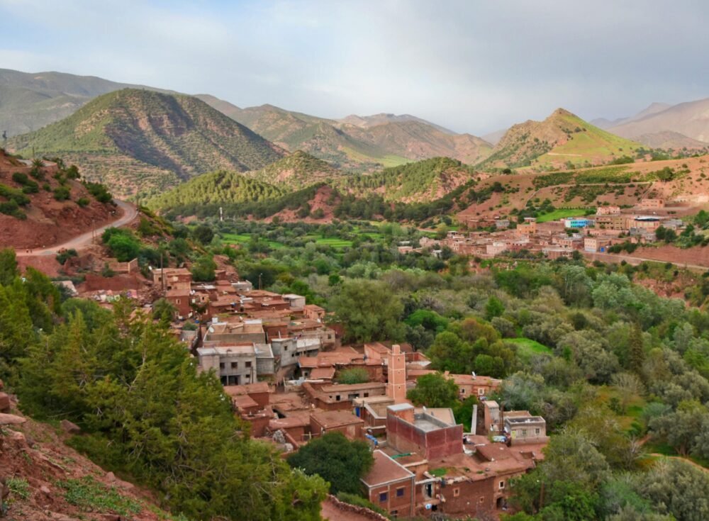 Scenic aerial view of Ait Barka village amidst lush green valleys and rugged mountains.