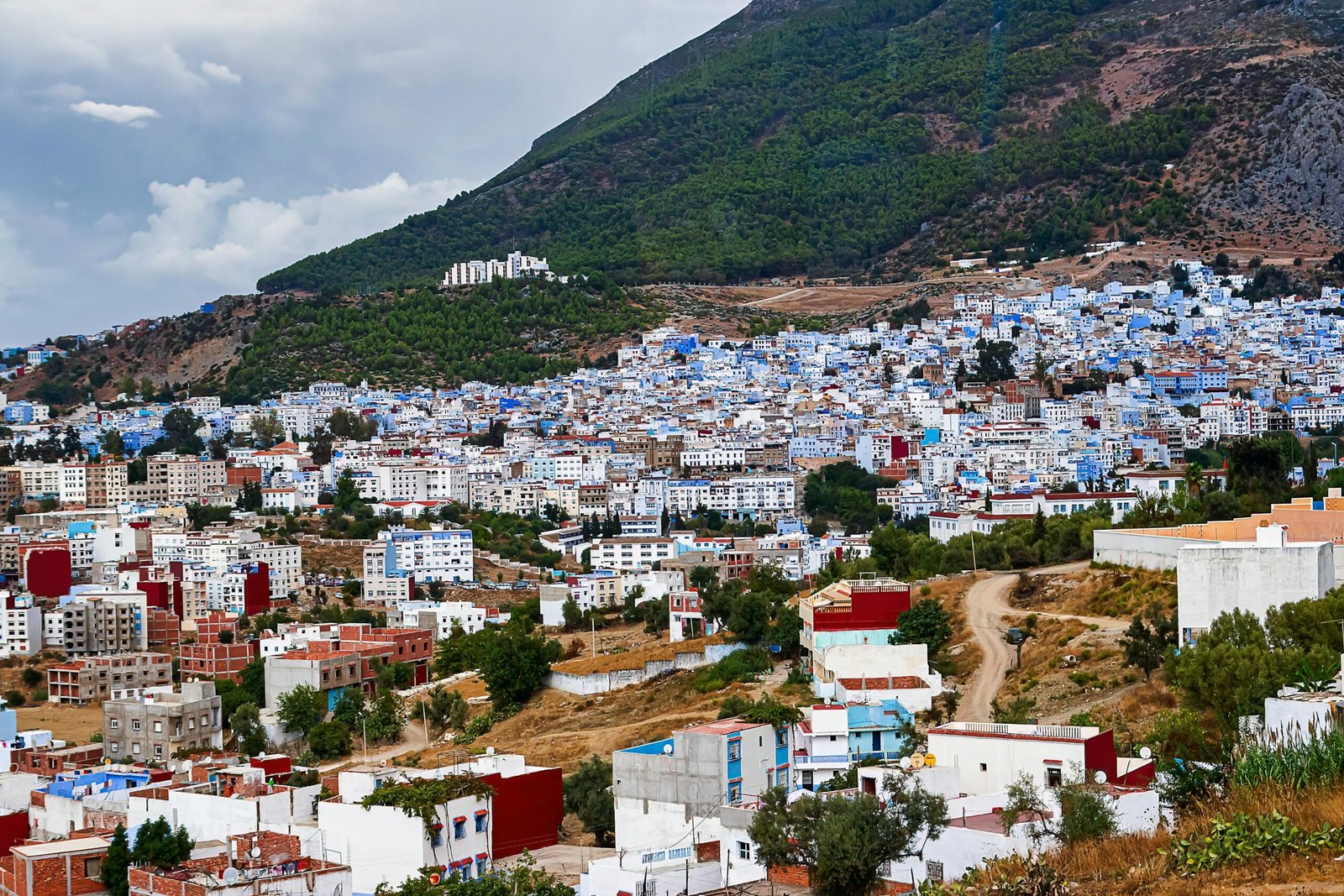 A vibrant panorama of Chefchaouen with its iconic blue buildings nestled in the mountains.